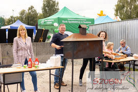 Uśmiechnięci ludzie przy grillu.